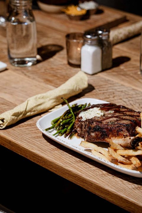 Bone-in ribeye plated at a candlelit table
