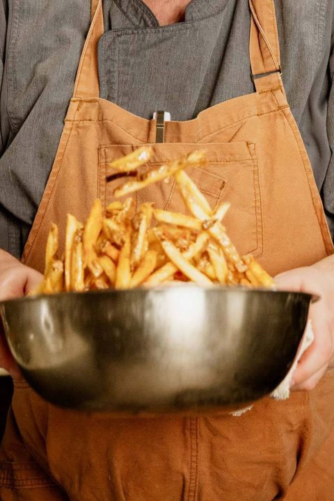 Chef holding a bowl of hand-cut fries
