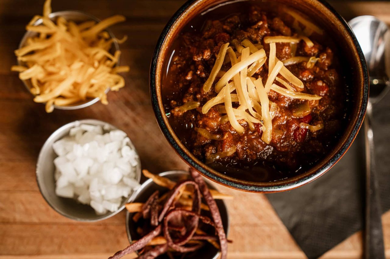 House chili with cheddar, onions, and tortilla strip garnishes