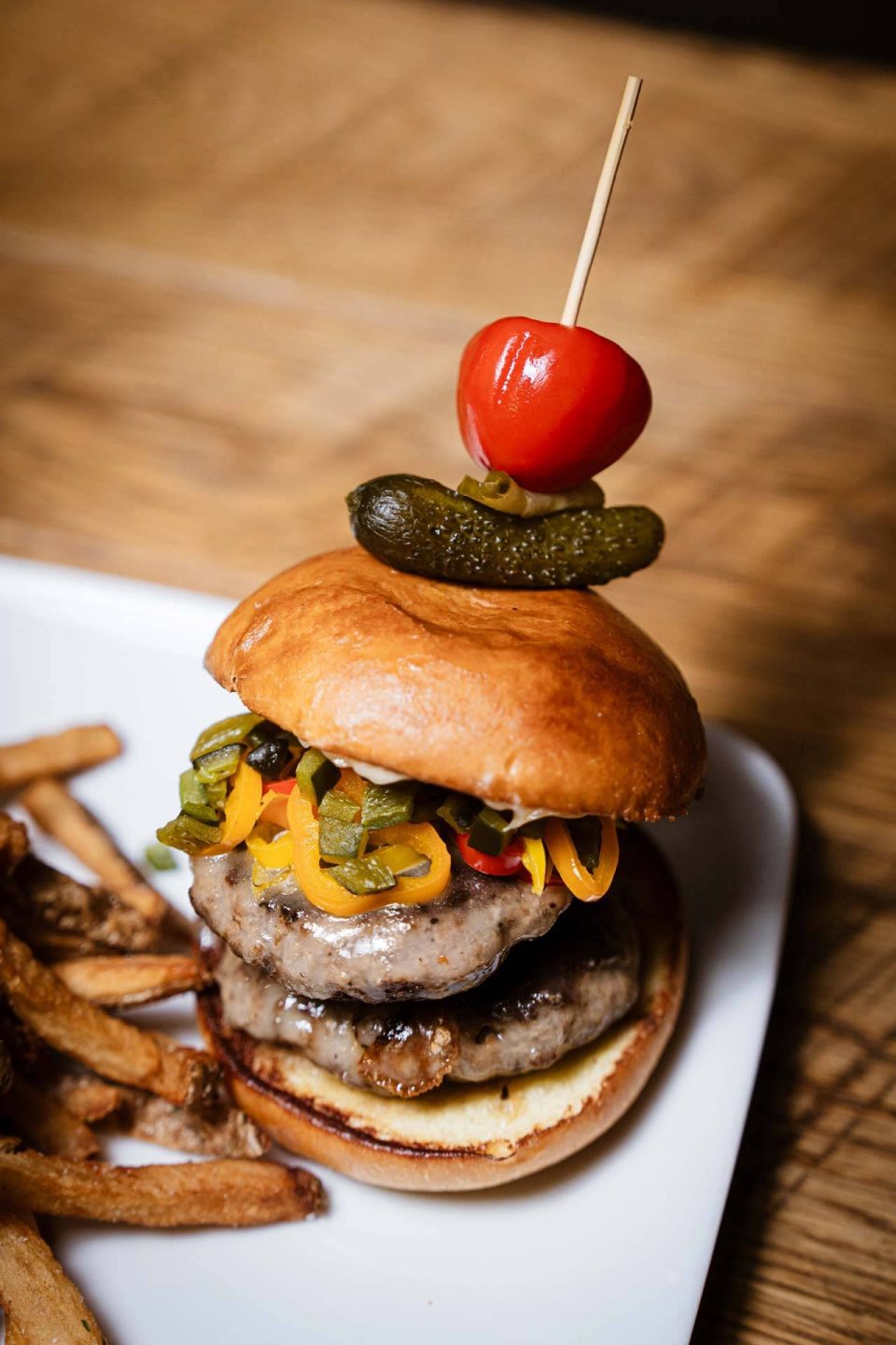 Double smash burger with hot peppers and pickle skewer